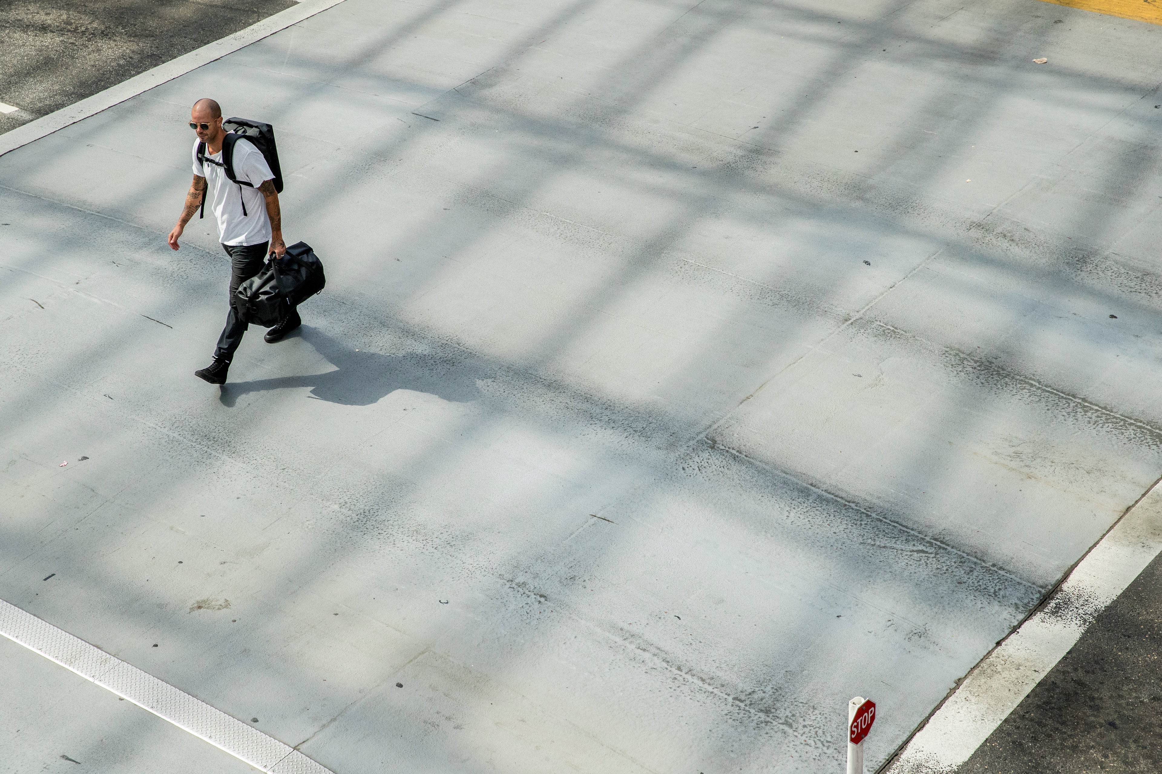 Person walking with a suitcase on a concrete surface