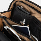 Close-up of opened SLNT E3 Faraday Crossbody Organizer Bag with items such as a camera, pens and notepads tucked into the pockets inside